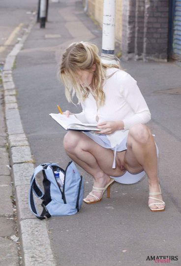 college girl on the ground writing in her agenda having a accidental upskirt moment showing her pussy