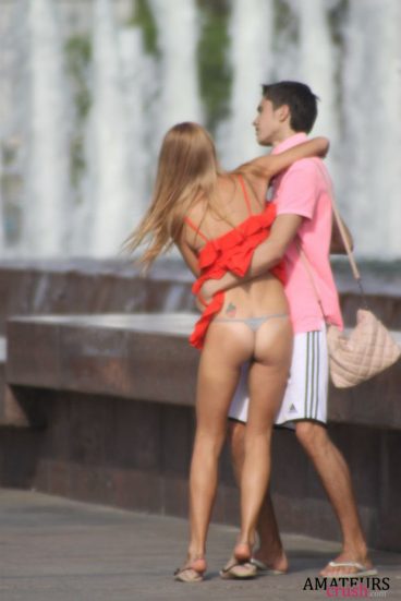 accidental upskirt of couple hugging in public showing tight ass under red dress