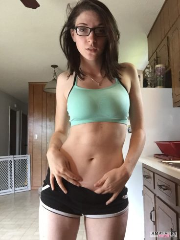 Teasing girl with glasses in green top and tight shorts